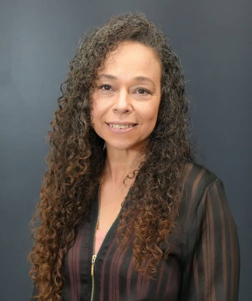 Fausta Hirn at The Rock Church USA, smiling and standing against a dark background.